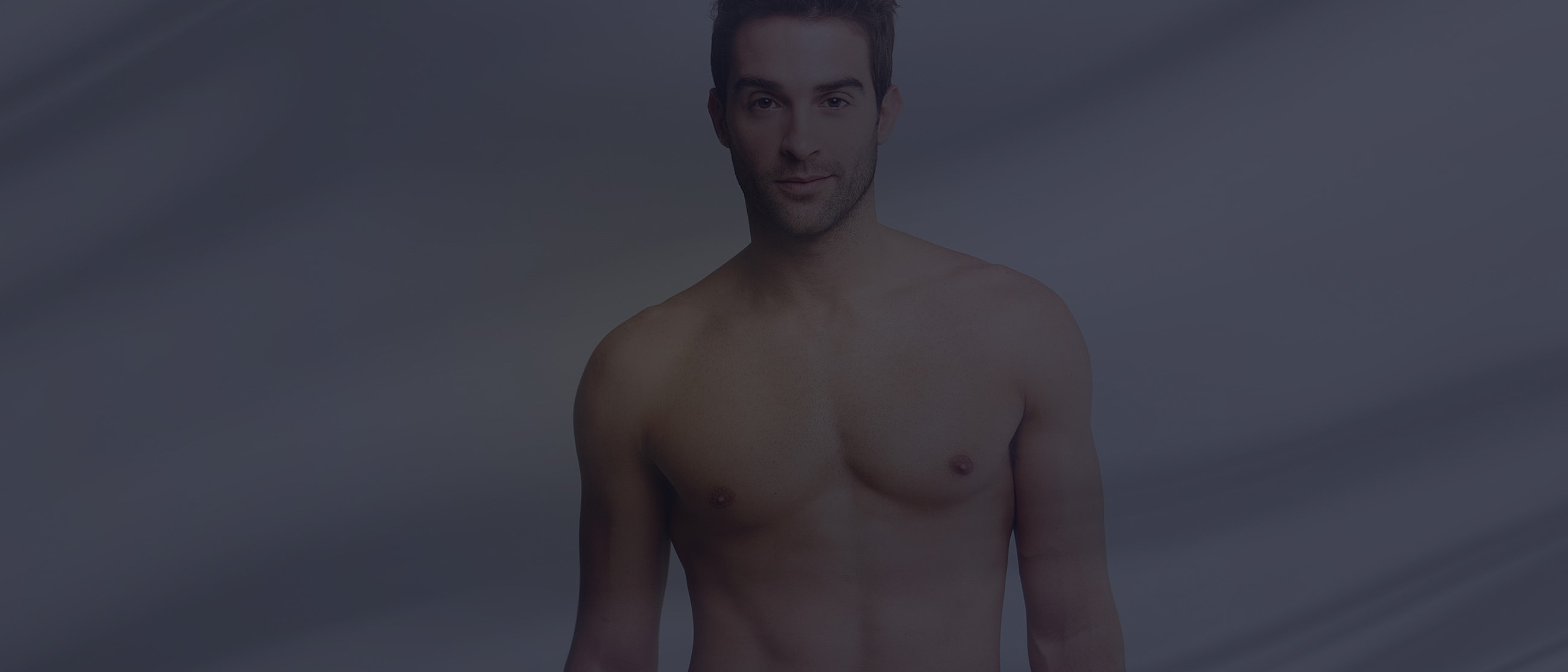 Portrait of a shirtless man against a gradient background.