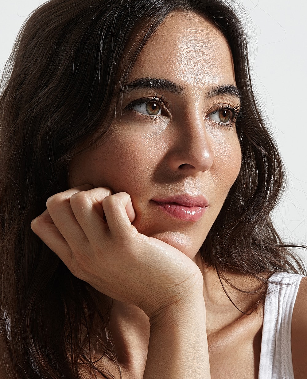 Woman resting chin on hand, thoughtful expression.