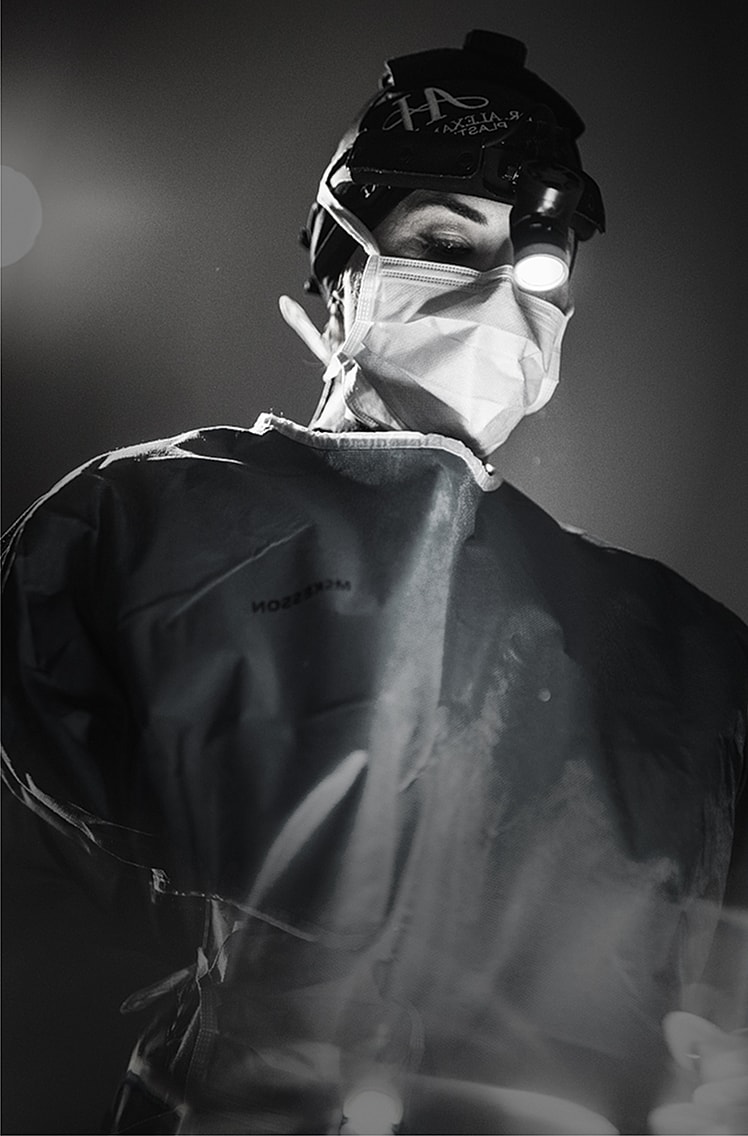 Surgeon in protective gear with headlamp.