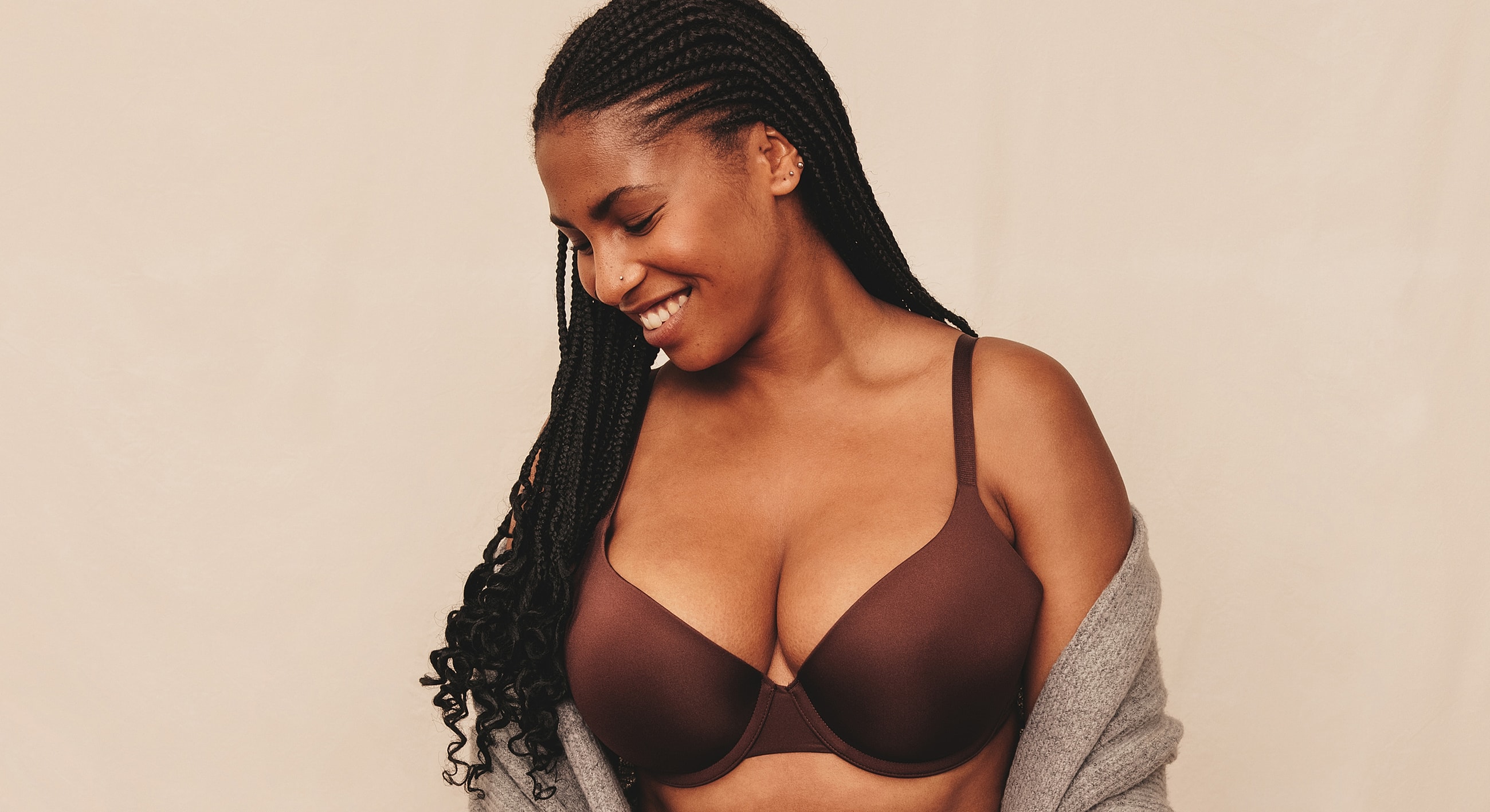 Smiling woman wearing a brown bra and sweater.