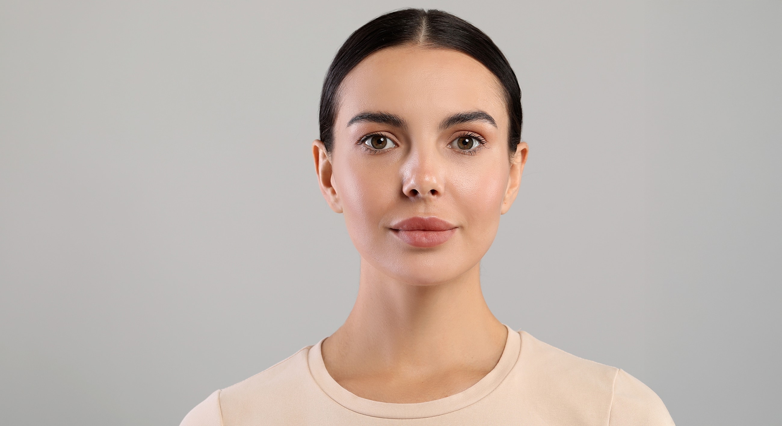 Woman with neutral expression against light background